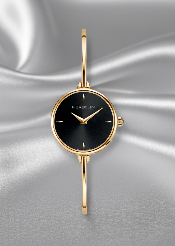 Gold watch with black face on a gray fabric background