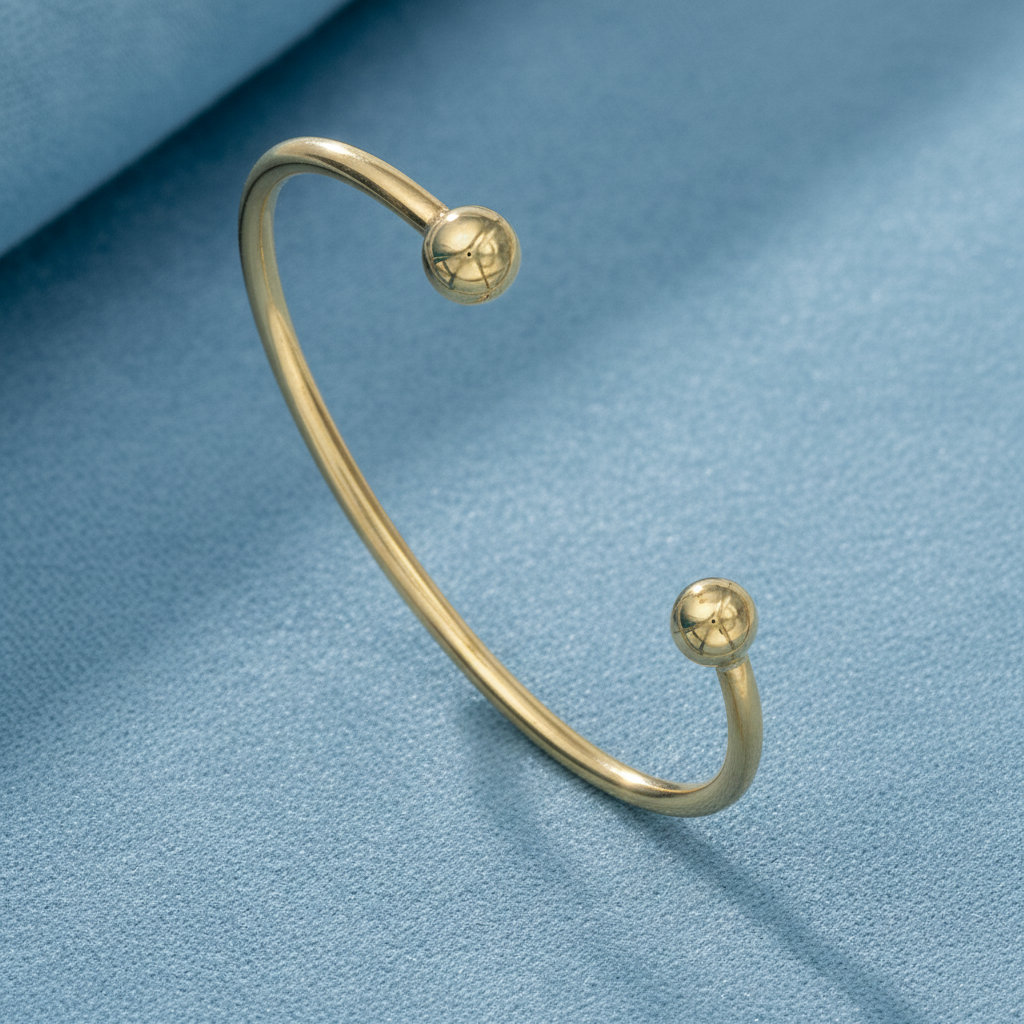 9ct Yellow Gold Open Torque Bangle on Textured Blue Fabric