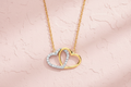 9ct Yellow & White Gold CZ Joined Hearts Pendant Necklace on blush pink textured background
