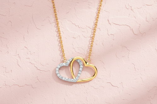 9ct Yellow & White Gold CZ Joined Hearts Pendant Necklace on blush pink textured background