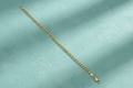 9ct Yellow Gold 4mm Curb Chain on teal textured background