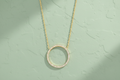 9ct Yellow Gold Circle of Life CZ Pendant Necklace on sage green textured background
