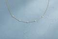 9ct Yellow Gold CZ By The Yard Bracelet & Necklace Set on dusty blue textured background