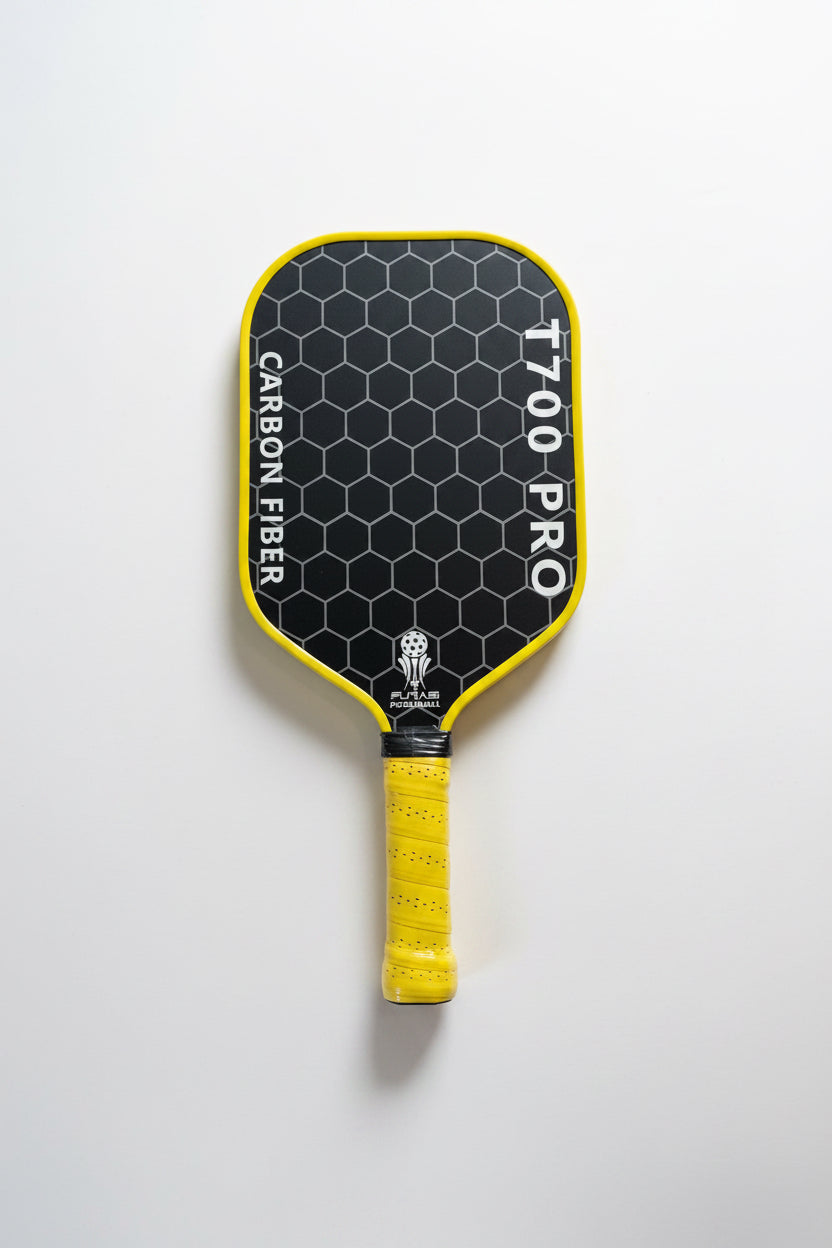 Pickleball paddle with black surface and yellow handle on a light gray background