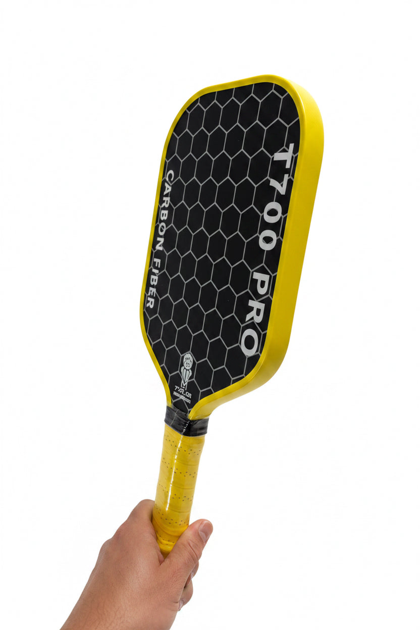 Yellow paddle with '1700 Pro' branding held against a textured gray background