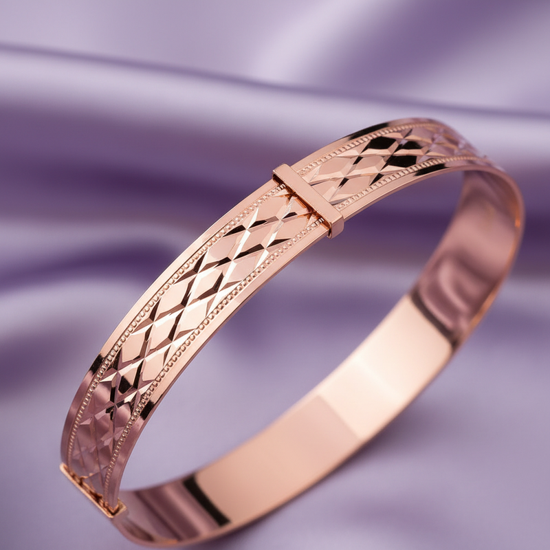 Rose gold bracelet with intricate design on a purple fabric background