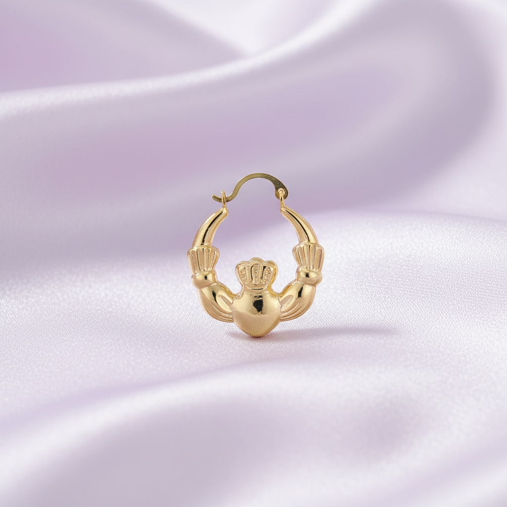 Gold claddagh hoop earring on a white background