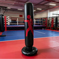 Black punching bag with red target symbol in a boxing ring.