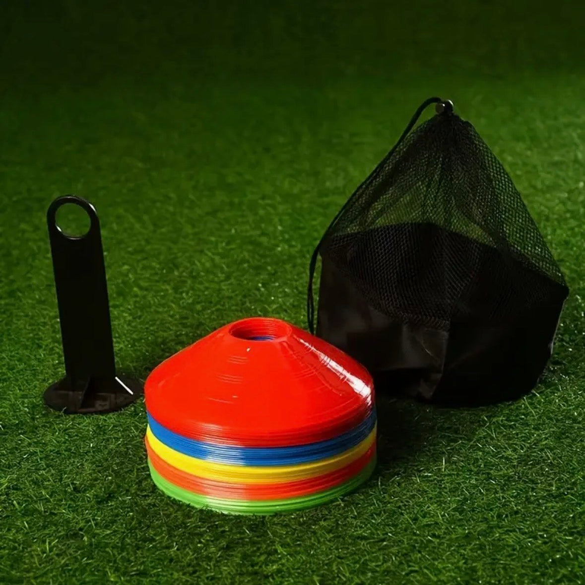 Colorful training markers with a black carrying bag on a green grass background