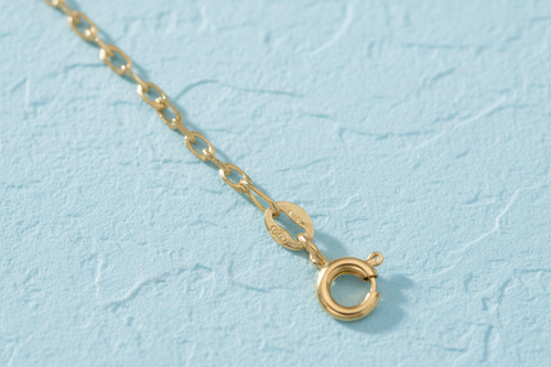 9ct Yellow Gold 1.7mm Diamond Cut Oval Belcher Chain on icy blue textured background