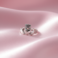 Silver Claddagh ring on pink silk background