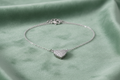 Silver CZ pavé heart pendant on sage green velvet background