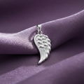 Silver Rhodium Angel Wing Charm Pendant on textured dusty lilac fabric background