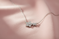 Silver rhodium plated CZ double flower pendant on blush pink background