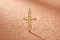 9ct Yellow Gold Round Tube Crucifix Pendant on terracotta textured background