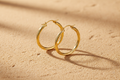 9ct Yellow Gold 36mm Twisted Hoop Earrings on warm sand textured background