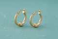 9ct Yellow Gold 17mm Glitter Ball Hoop Earrings on teal textured background