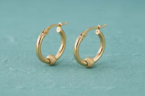 9ct Yellow Gold 17mm Glitter Ball Hoop Earrings on teal textured background