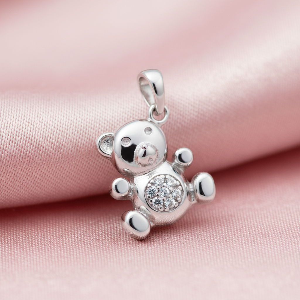 Silver Rhodium CZ Teddy Bear Charm Pendant on soft blush pink fabric background