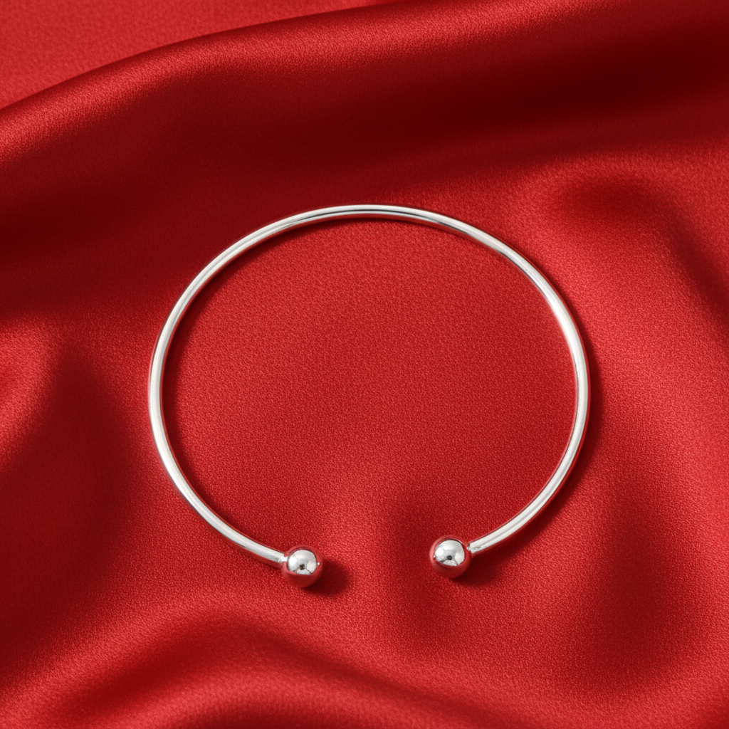 Silver Ladies Torc Bangle with open ball ends on soft red silk background