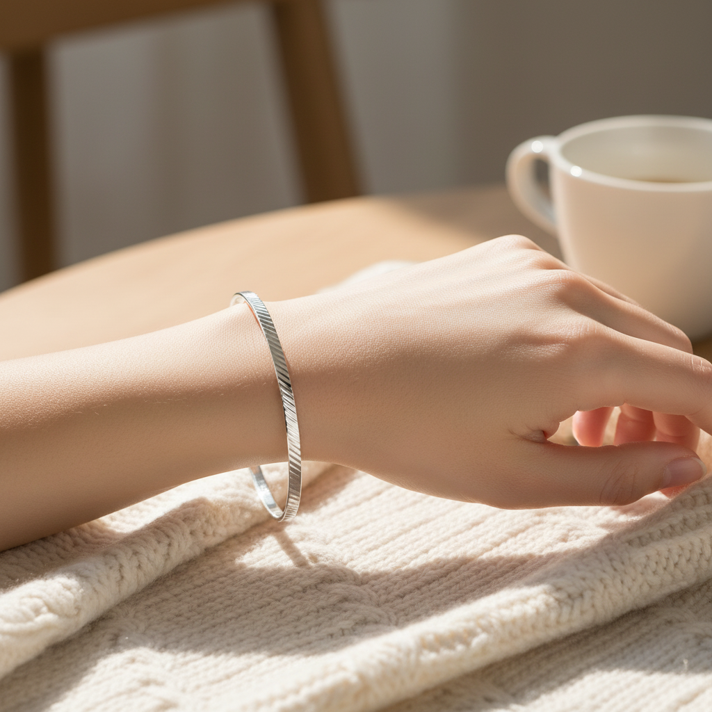 Silver Ladies Round Diamond Cut Bangle worn on a womans wrist