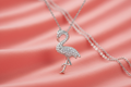 Silver rhodium plated CZ flamingo pendant on coral pink background