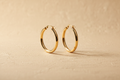 9ct Yellow Gold Plain Tube Hoop Earrings on champagne textured background