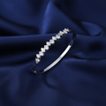 Silver Ladies' Oval CZ Hinged Bangle flat lay on navy silk