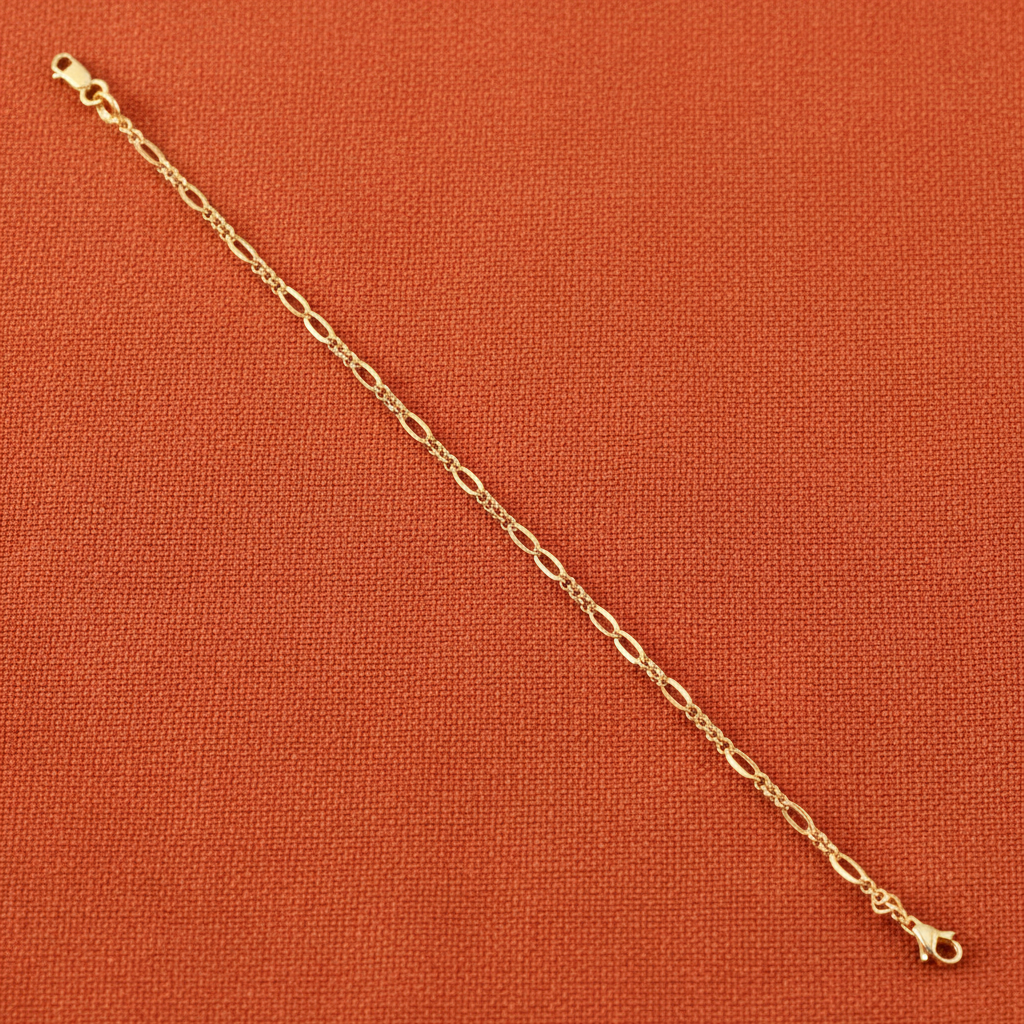9ct Yellow Gold Hollow Figaro Anklet on burnt orange textured background