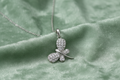 Silver rhodium plated CZ butterfly pendant on sage green background