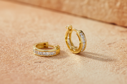 9ct Yellow Gold 12mm Princess Cut CZ Huggie Earrings on warm amber textured background