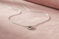 Silver rhodium plated CZ open heart pendant on blush pink velvet background