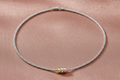 Silver rhodium plated mesh necklet with gold rings on rose gold silk background