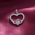 Silver Rhodium CZ Heart Claddagh Pendant on textured rose pink fabric background
