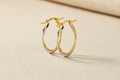 9ct Yellow & White Gold Two Colour Twist Oval Hoop Earrings on cream linen textured background