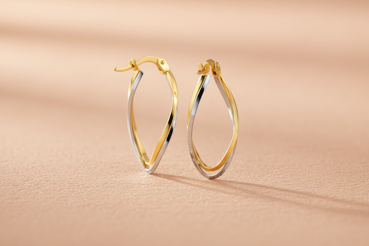 9ct Yellow & White Gold Twist Oval Hoop Earrings on peach textured background