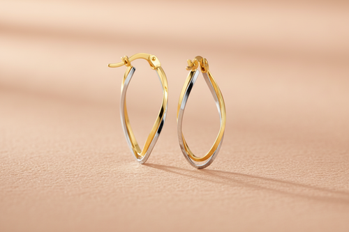 9ct Yellow & White Gold Twist Oval Hoop Earrings on peach textured background